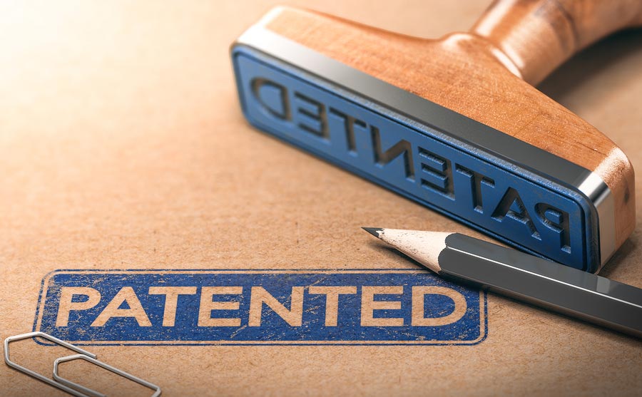 The rubber stamp in the photo, saying "patented," represents the end goal of this article, "How to Patent a Product."